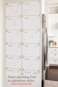 Un calendrier familial coloré et rempli d'activités estivales sur une table en bois.